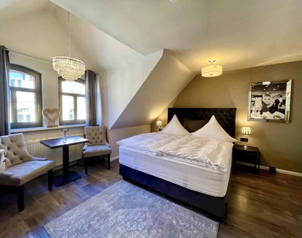 a bedroom with a bed and a table and chairs at Pension Burkhardt in Meißen