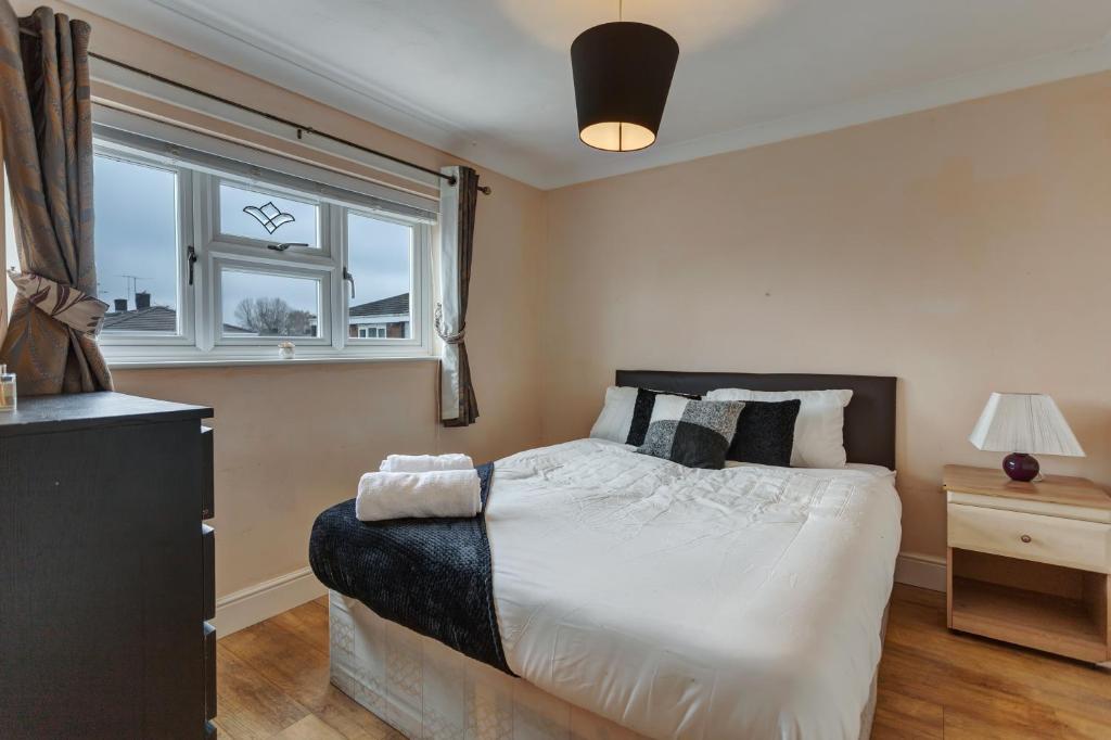una camera con un grande letto e una finestra di Spacious & Centrally Located Home in Basildon With Parking Close to Town Centre a Basildon