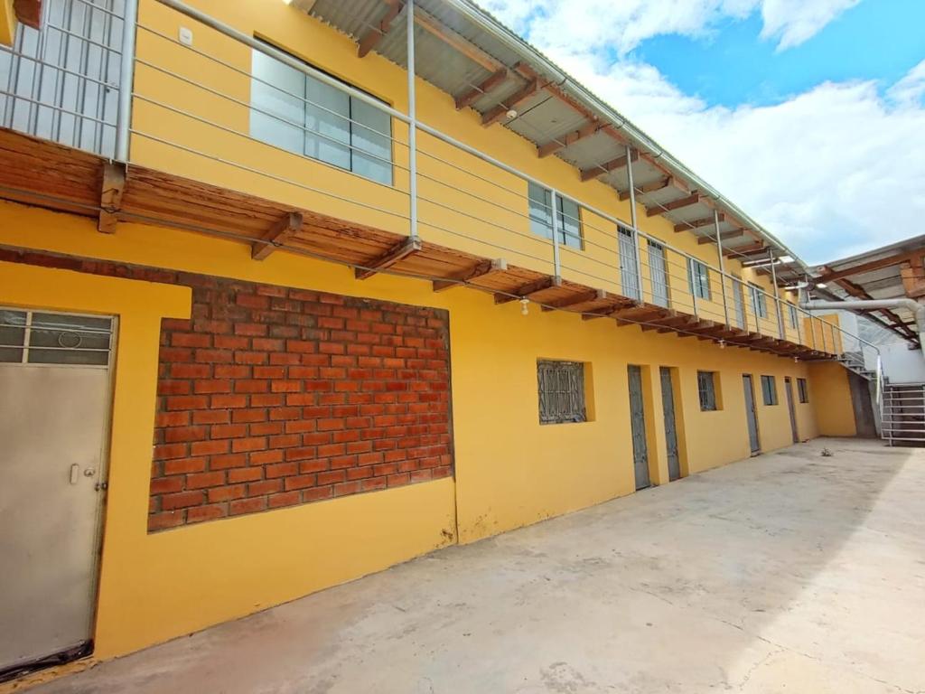 un edificio escolar vacío con pintura amarilla y pared de ladrillo en OCALA HOUSE 4.0 en Huánuco