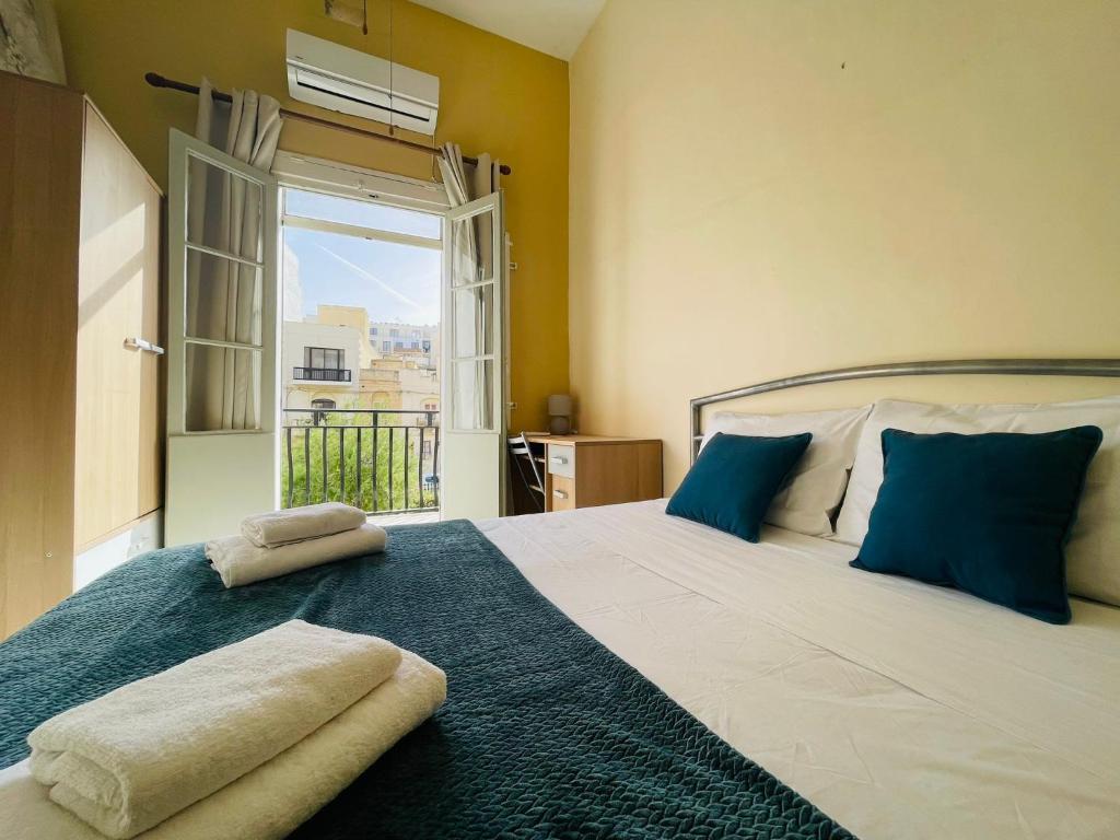 馬薩爾福恩的住宿－Beach House - Seaview Holiday Home，一间卧室配有一张带蓝色枕头的床和一扇窗户。