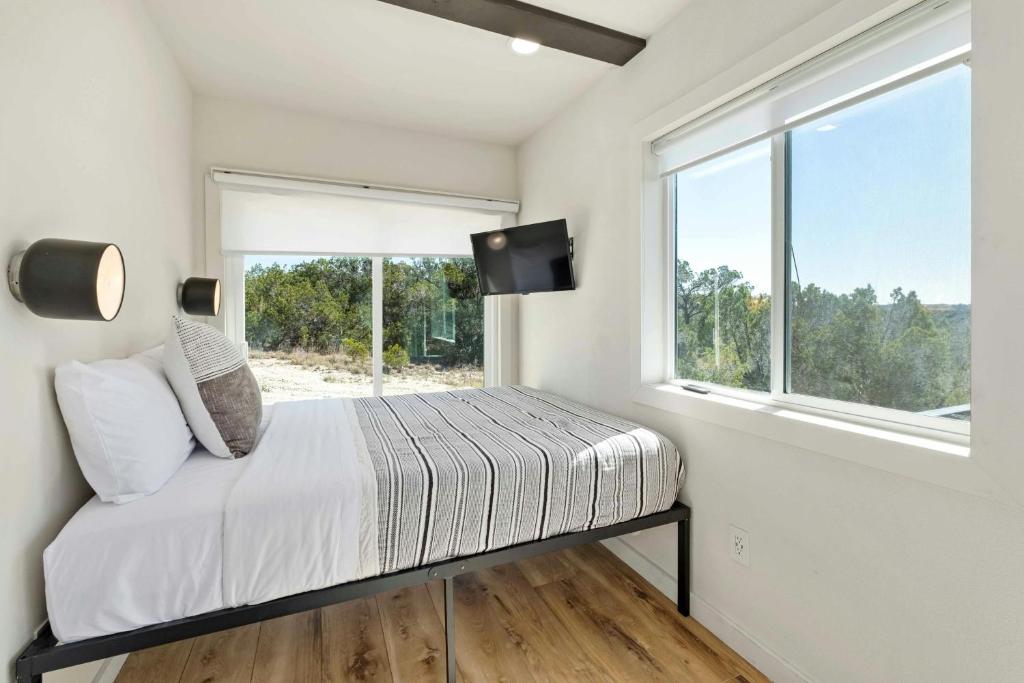 a bedroom with a bed and a window at Hill Country Norwood Tiny Home B- Sits on 13 Acres, Sleeps 2 and Pet Friendly! in Dripping Springs