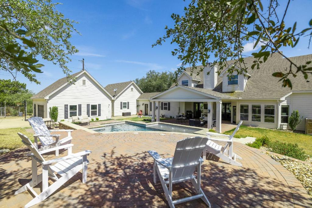 a house with two chairs and a swimming pool at Peaceful Country Charm with Private Pool in Dripping Springs