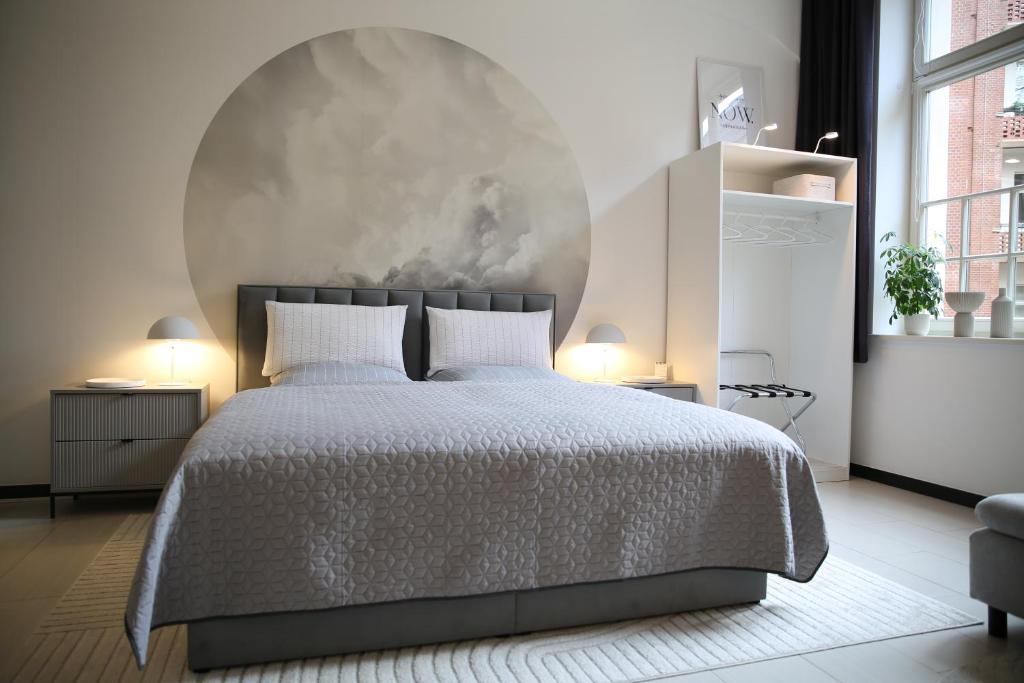 a white bedroom with a bed and a large wall at MEOS 3 -Zentrum-Hofblick-Gym-Netflix in Leipzig