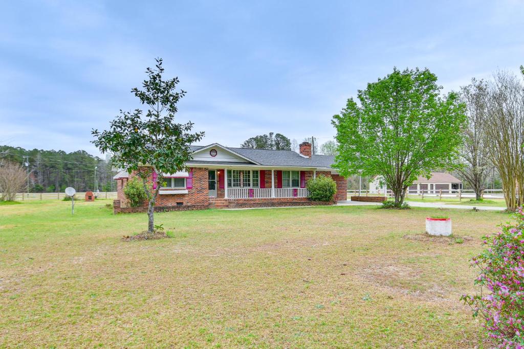 una casa con un albero nel cortile di Quiet and Cozy Rembert Home about 9 Mi to Air Force Base 