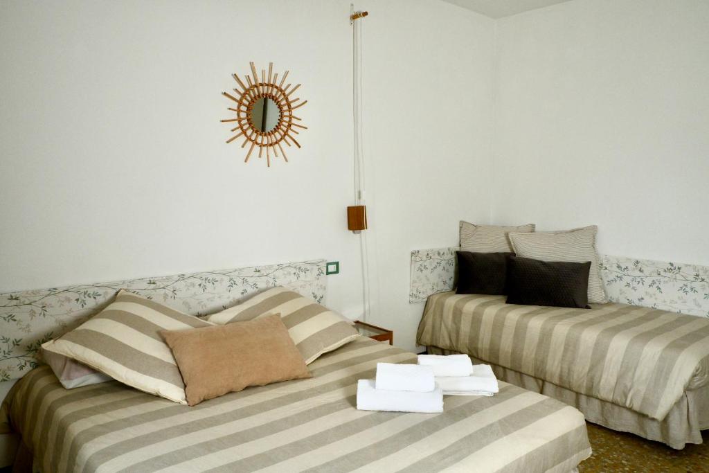 a room with two beds and a clock on the wall at appartamento la Bastia fra il lago di Garda e Brescia città in Nuvolento