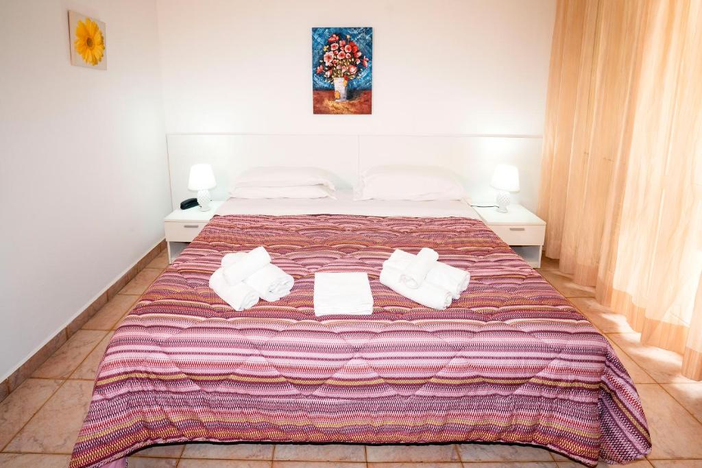 a bedroom with a large bed with towels on it at Hotel Fernanda in Letojanni