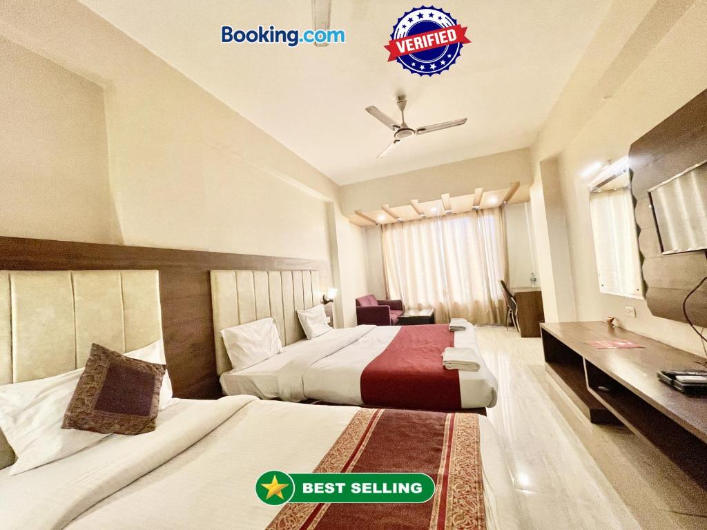 um quarto de hotel com duas camas e uma secretária em Hotel Rudraksh ! Varanasi ! fully-Air-Conditioned hotel at prime location with Parking availability, near Kashi Vishwanath Temple, and Ganga ghat em Varanasi