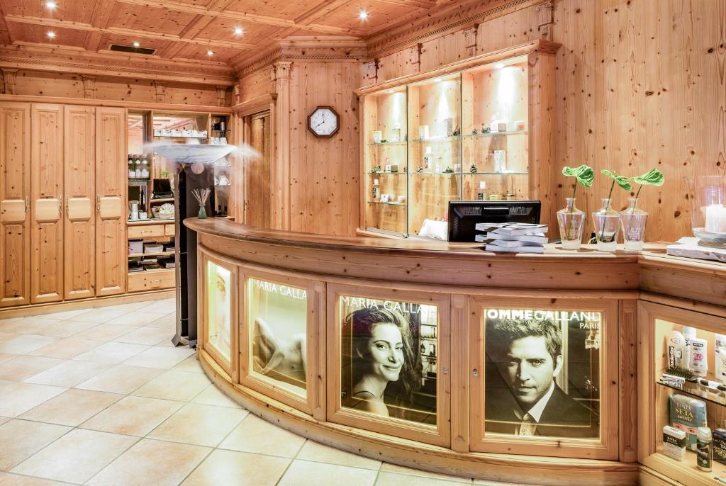 a bar in a store with a clock on the wall at Hotel Alpenroyal - The Leading Hotels of the World in Selva di Val Gardena