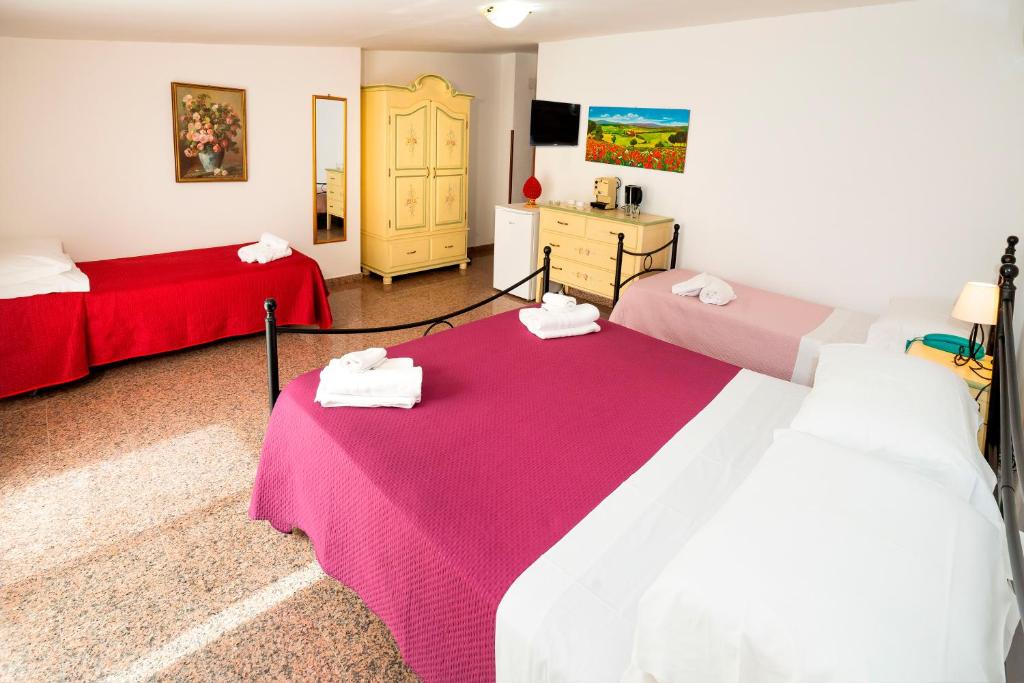 a room with two beds and a dresser in it at Hotel Fernanda in Letojanni