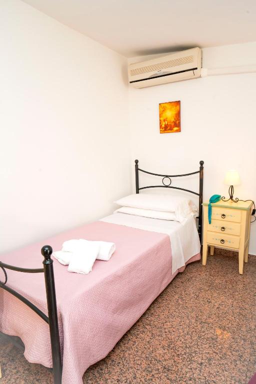 a bedroom with a bed with a pink blanket at Hotel Fernanda in Letojanni