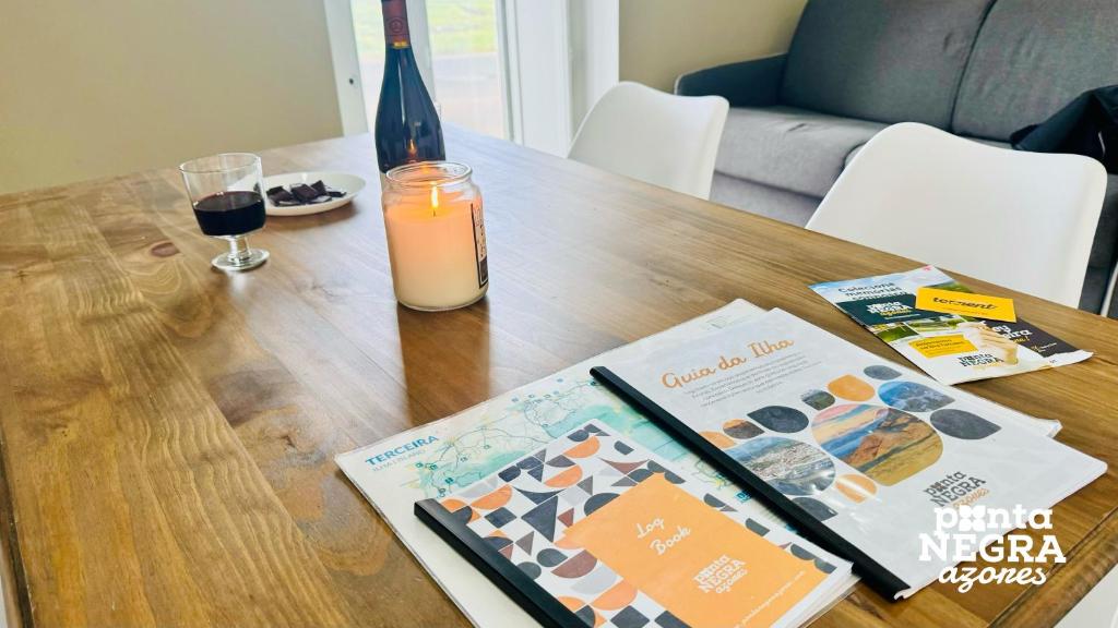 un tavolo con un libro e una candela e una rivista di Casa das Lajes a Caldeira