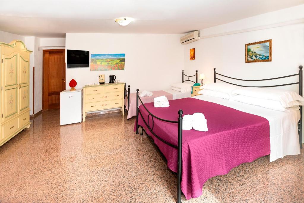 a bedroom with a large bed with a pink blanket at Hotel Fernanda in Letojanni