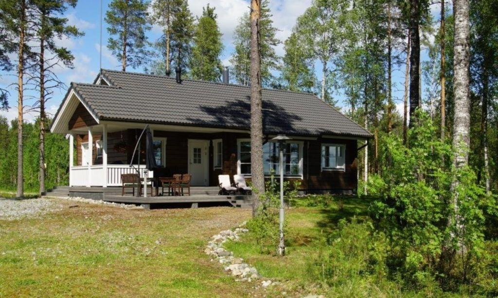 a small house in the middle of a forest at Hochwertiges Ferienhaus mit Sauna sowie Holzterrasse und Garten am See in Sotkamo