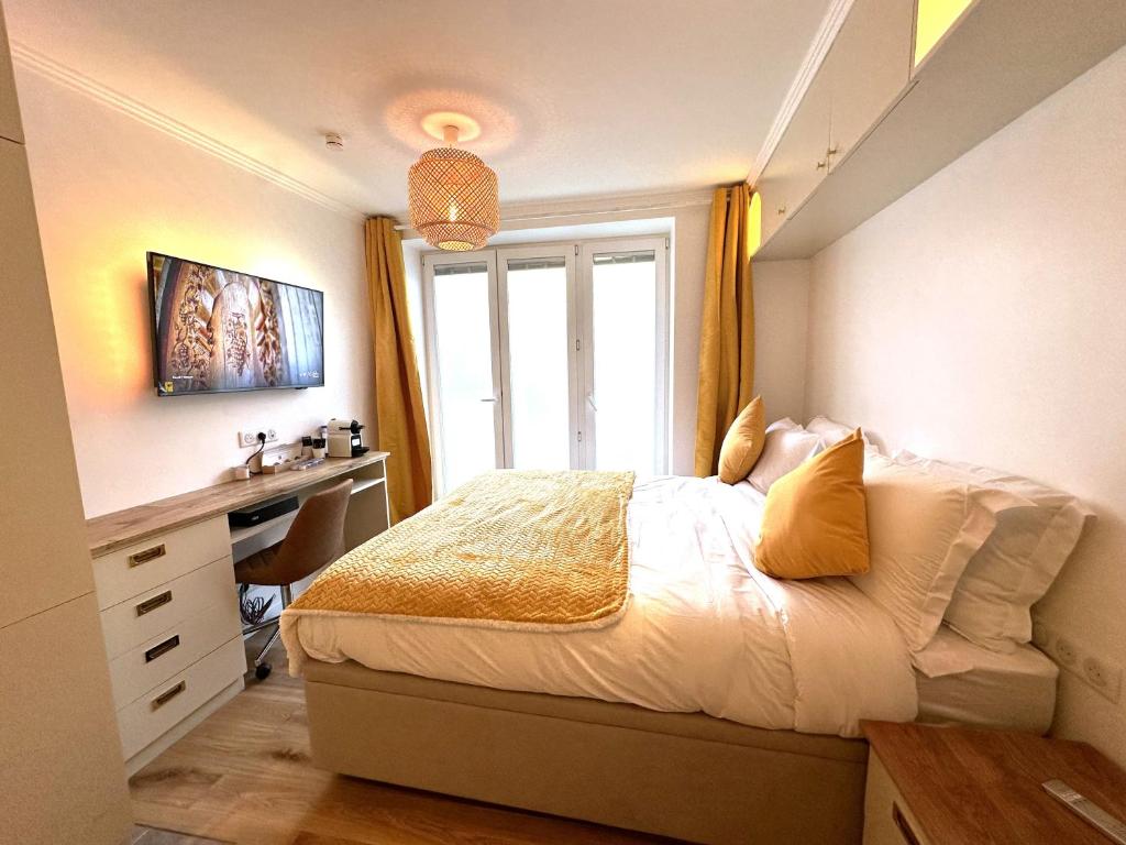 een slaapkamer met een bed, een bureau en een raam bij Parisien Hôtel style in Pré Saint Gervais