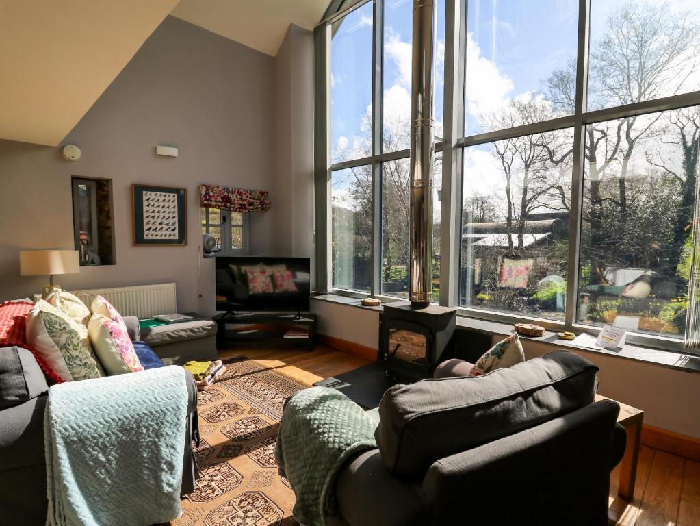 a living room with two couches and a large window at The Barn at Glanoer in Bettws Disserth