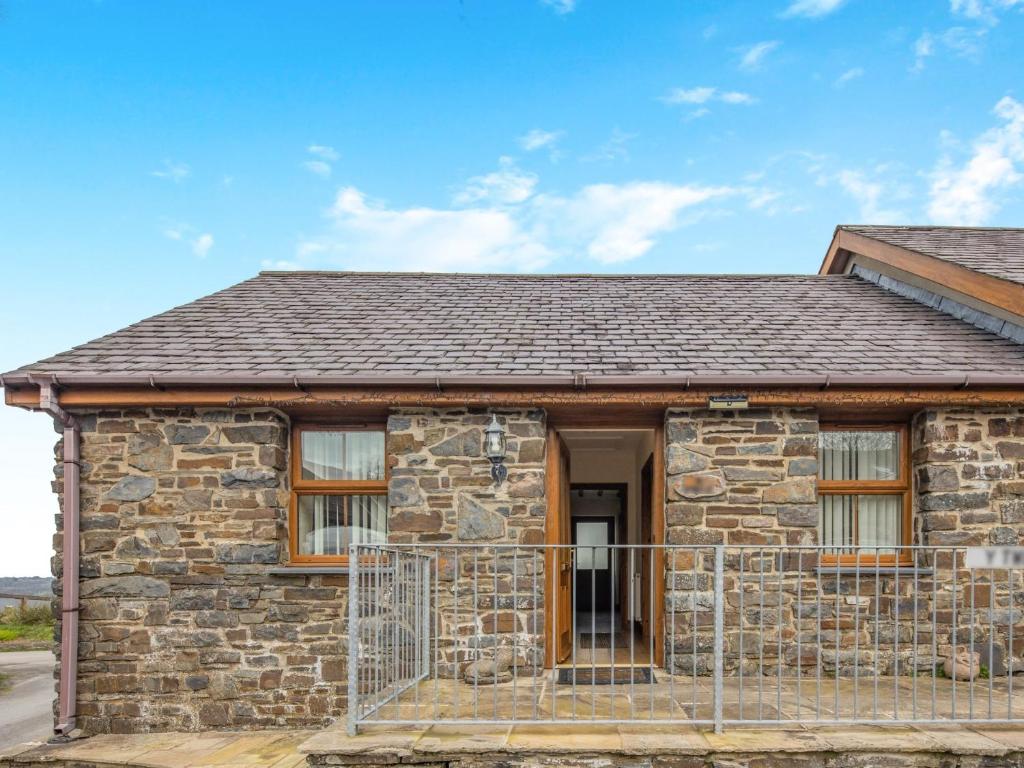 a stone house with a gate in front of it at 2 Bed in Aberystwyth TWLCT in Llanfihangel-y-creuddyn