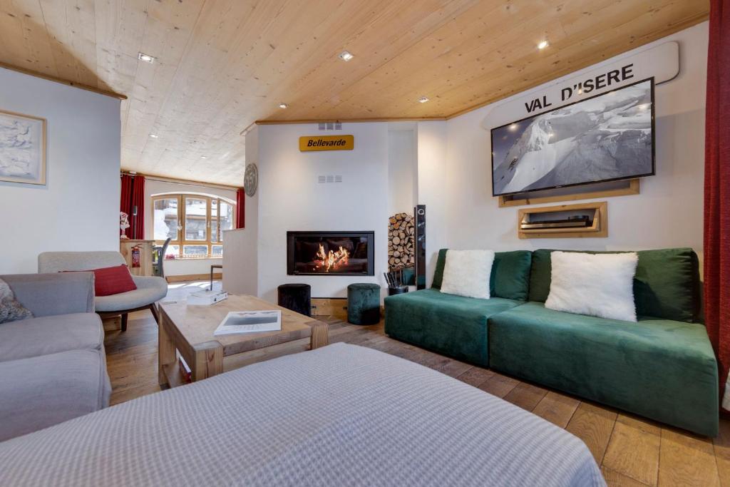 un salon avec un canapé et une cheminée dans l'établissement L'Aigle du Laisinant duplex de 90m2 à Val d'Isere, à Le Fornet