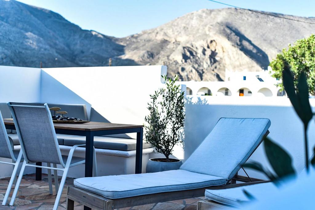 d'un balcon avec une table, des chaises et des montagnes. dans l'établissement DP Homes Santorini, à Perissa