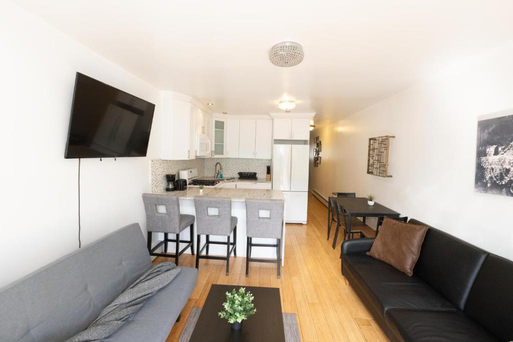 a living room with a couch and a kitchen at Close to NYC - Welcoming & Friendly 2-Bed Home in Union City