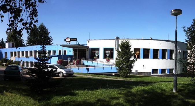 a building with a swimming pool in a parking lot at Hotel Rozvoj in Klatovy