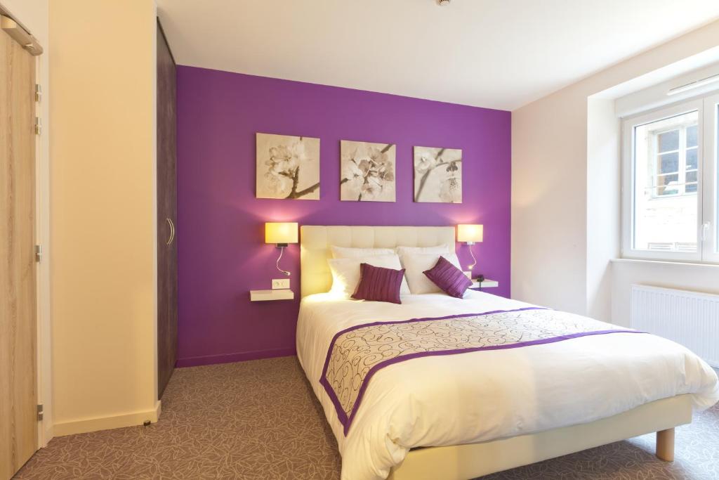 a bedroom with purple walls and a large bed at Le Relais D'arc Et Senans in Arc-et-Senans