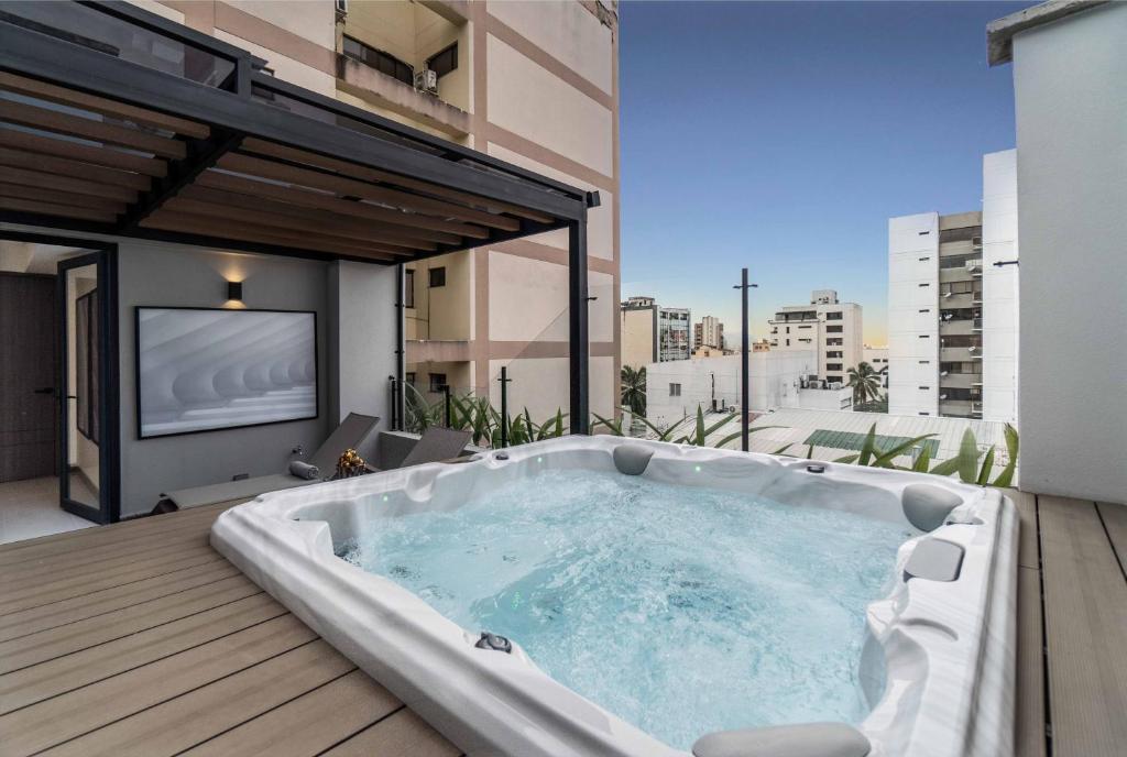 Un jacuzzi en un balcón con TV. en Hygge Luxury Apartments, en Cali