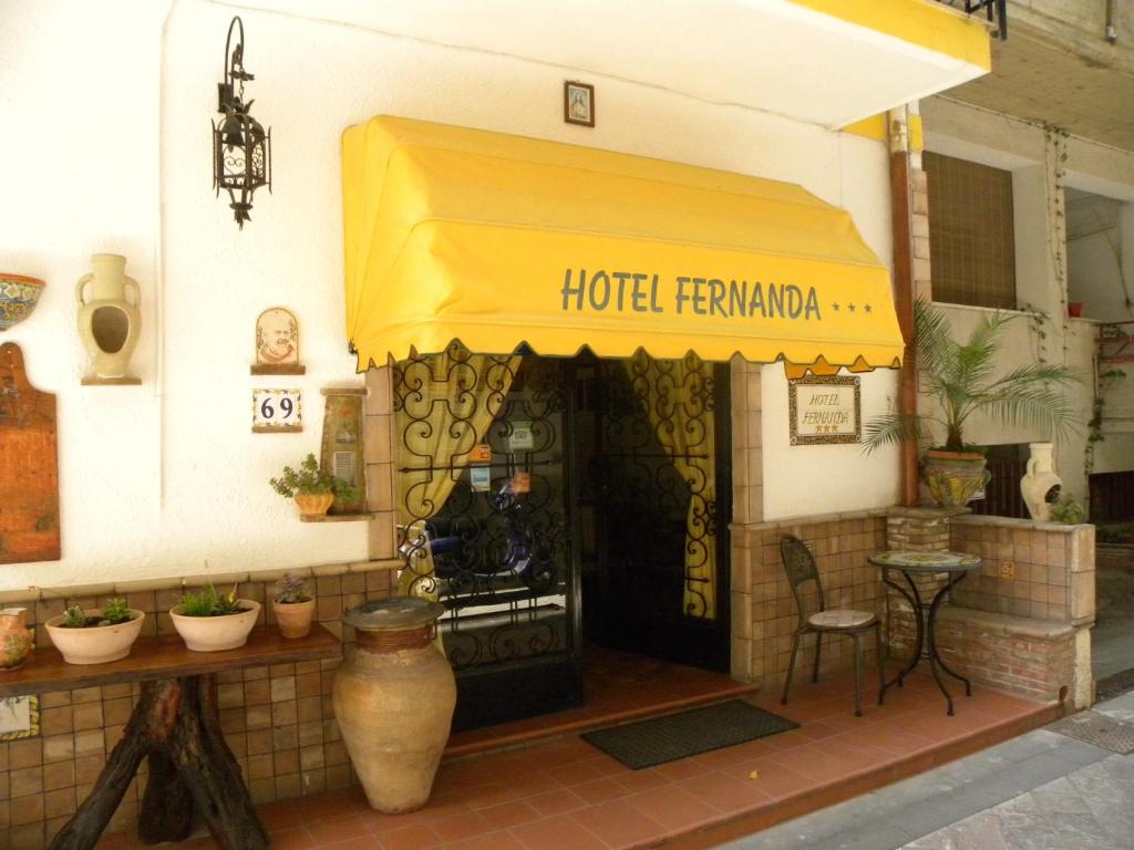ein Restaurant mit gelber Markise auf einem Gebäude in der Unterkunft Hotel Fernanda in Letojanni