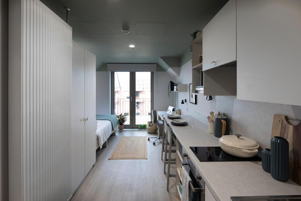 una cocina con fregadero y una cama en una habitación en Keel House refurbished Studios en Edimburgo