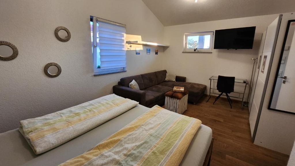 um quarto com uma cama, um sofá e uma televisão em Zettis Ferienhäusle em Berg bei Ravensburg