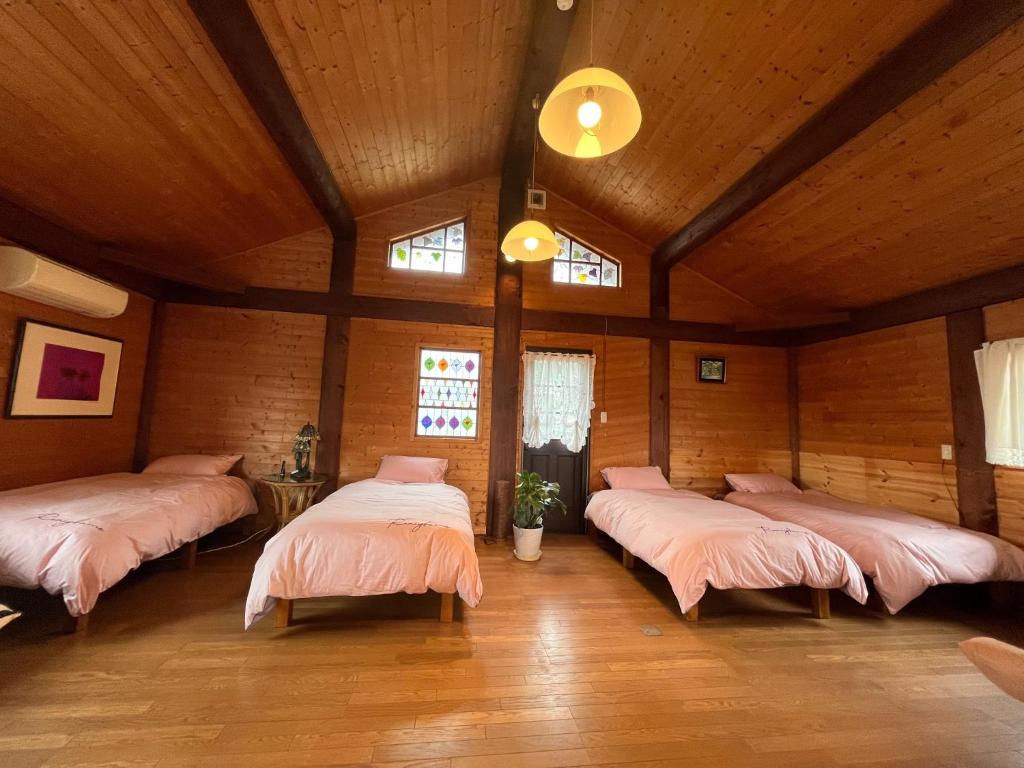 a room with four beds with pink sheets in it at beau lac biwako - Vacation STAY 25030v in Takashima