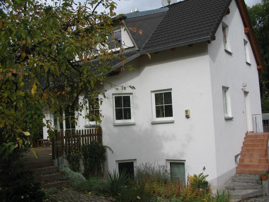 a white house with a black roof at Apartment Sonnenberge in Jena