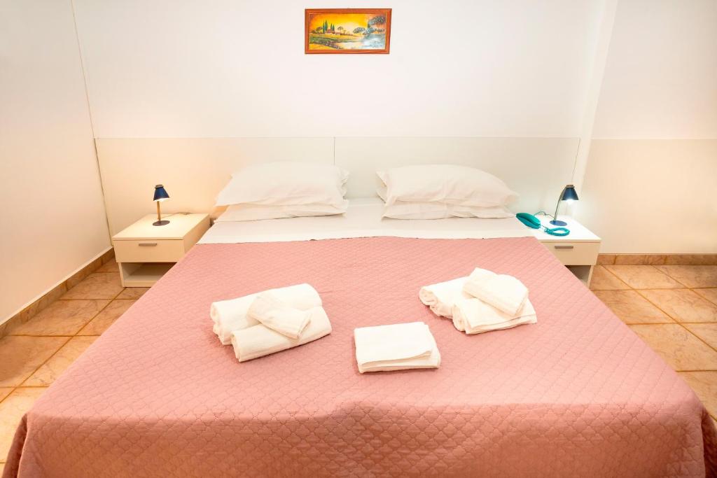 a bedroom with a large bed with two white towels at Hotel Fernanda in Letojanni