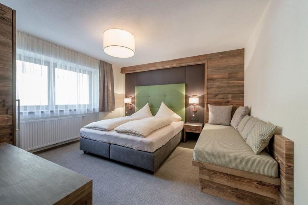 een slaapkamer met een bed en een bank erin bij Ferienwohnung für 4 Personen ca 54 qm in Sölden, Tirol Skigebiet Sölden in Sölden