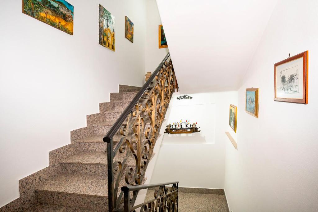 a staircase in a house with paintings on the wall at Hotel Fernanda in Letojanni