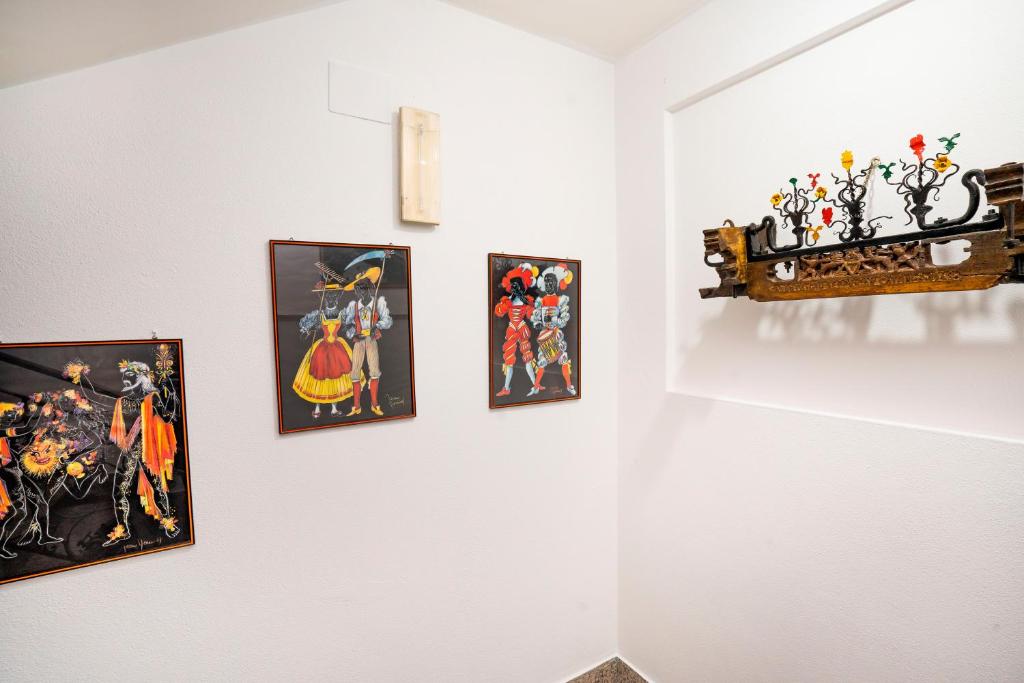 a group of paintings on a white wall at Hotel Fernanda in Letojanni