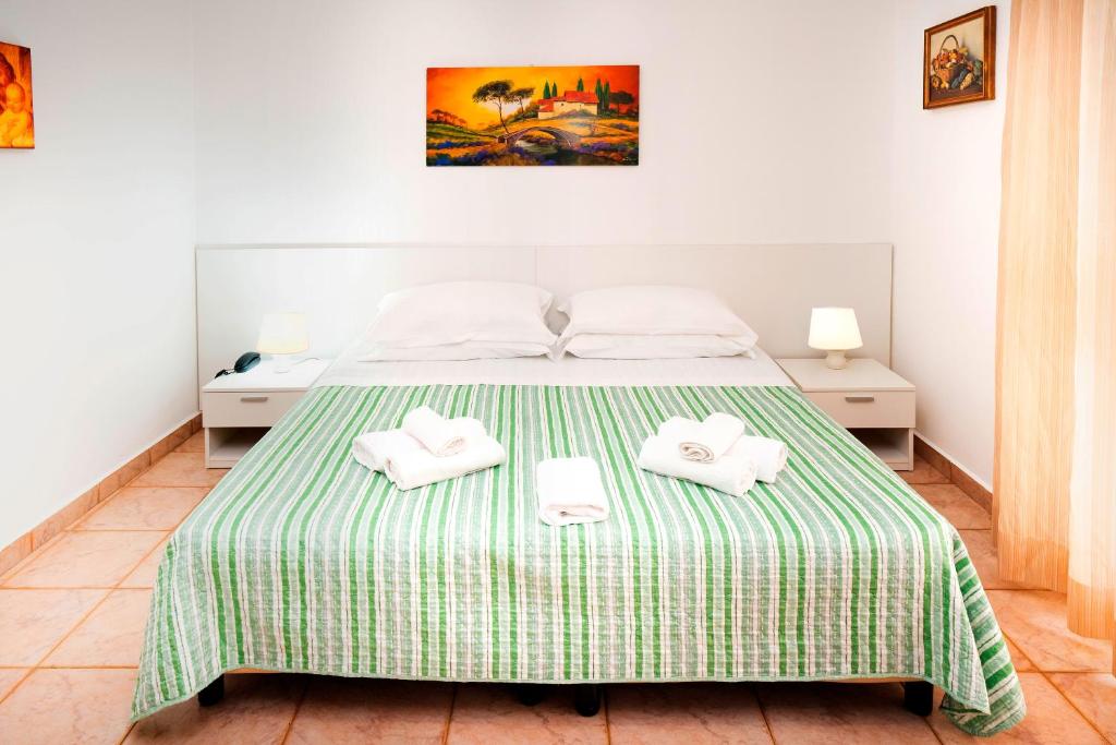 a bedroom with a bed with two towels on it at Hotel Fernanda in Letojanni