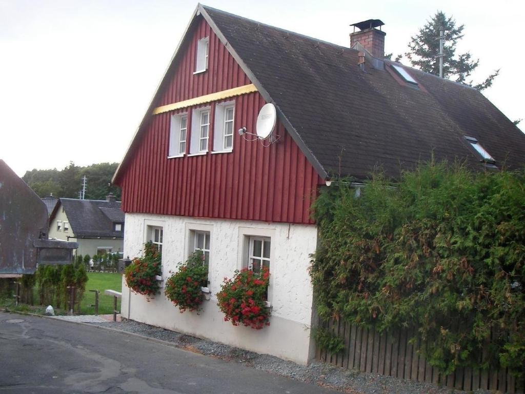 a red and white house with flower boxes on it at Ferienhaus "Lena" in Presseck
