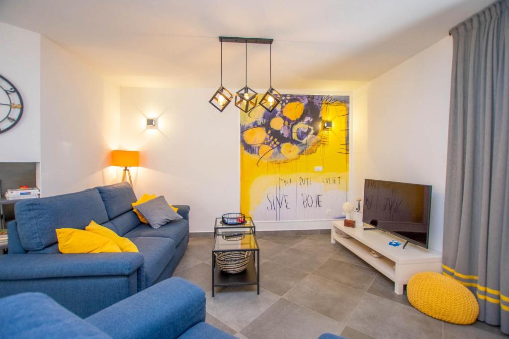 a living room with a blue couch and a tv at House Villa Verdi in Tkon