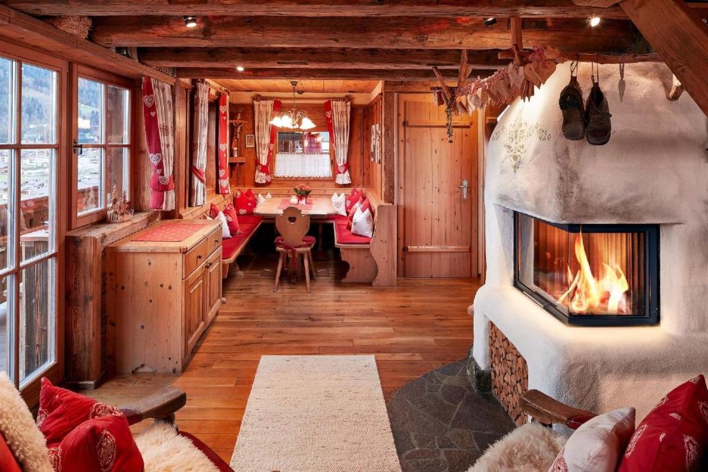 a living room with a fireplace in a house at Ferienhaus für zehn Erwachsene und zwei Kinder mit Sauna und Kamin in Flachau
