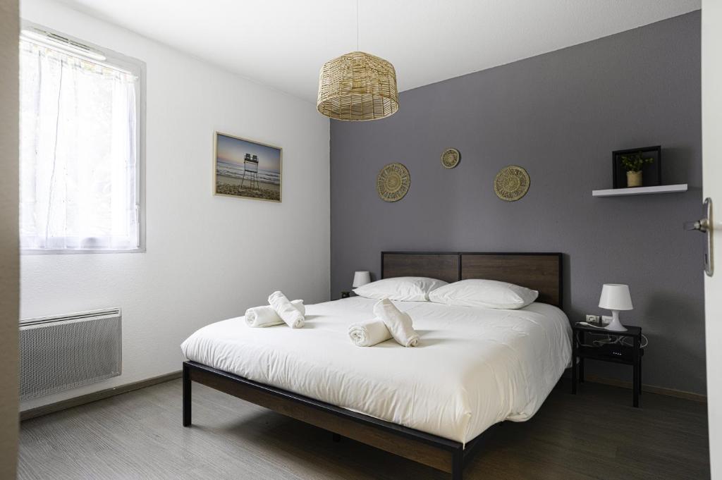 ein Schlafzimmer mit einem großen weißen Bett mit weißen Kissen in der Unterkunft Le Cocon Verdoyant in Toulouse