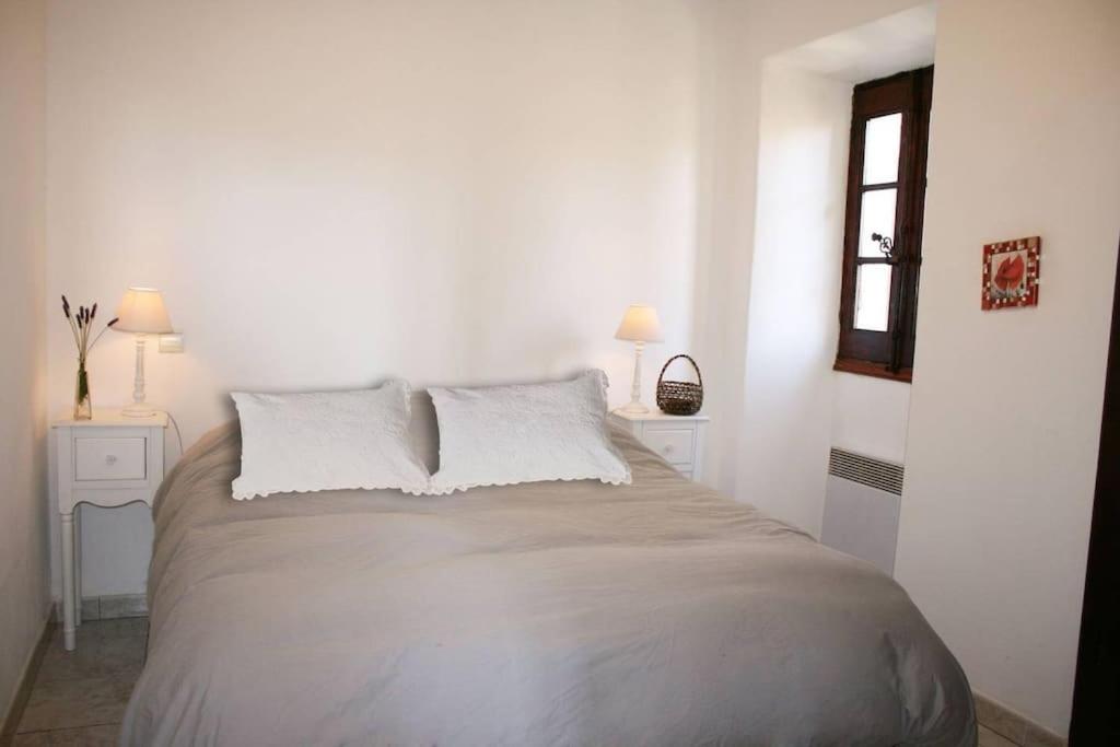 - une chambre blanche avec un grand lit et des oreillers blancs dans l'établissement Charme du village-Plage à 10mn, à Corbara