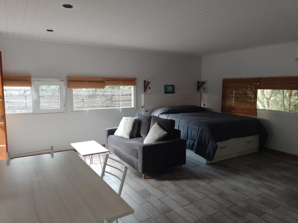 ein Schlafzimmer mit einem Bett und einer Couch in der Unterkunft La Escondida in Valeria del Mar