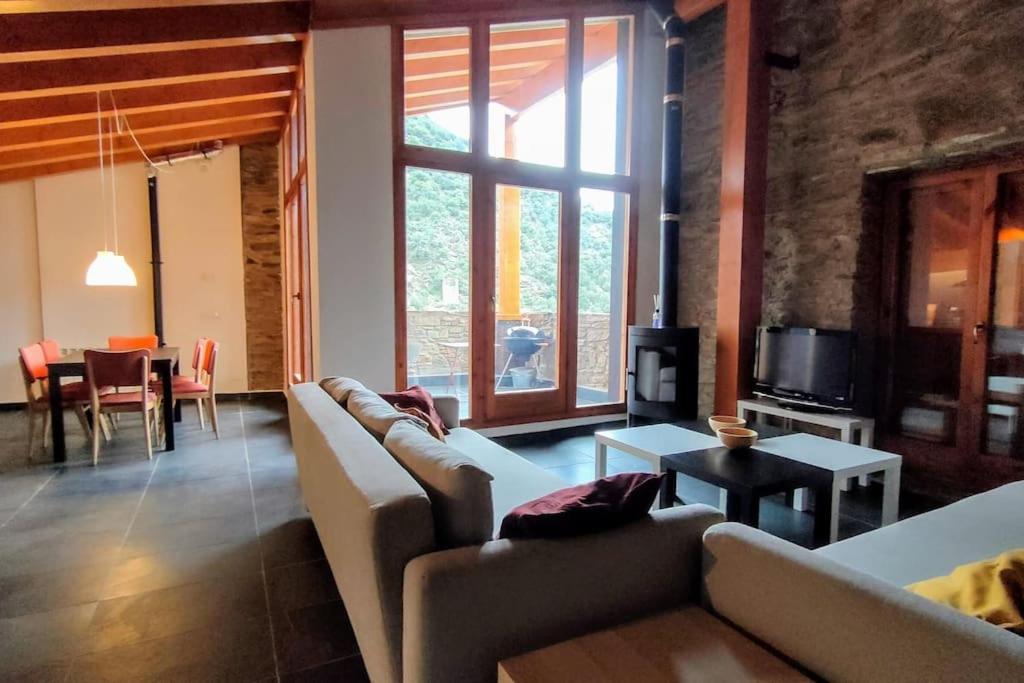 uma sala de estar com um sofá e uma mesa em Cal cavalé em Vall de Castellbò