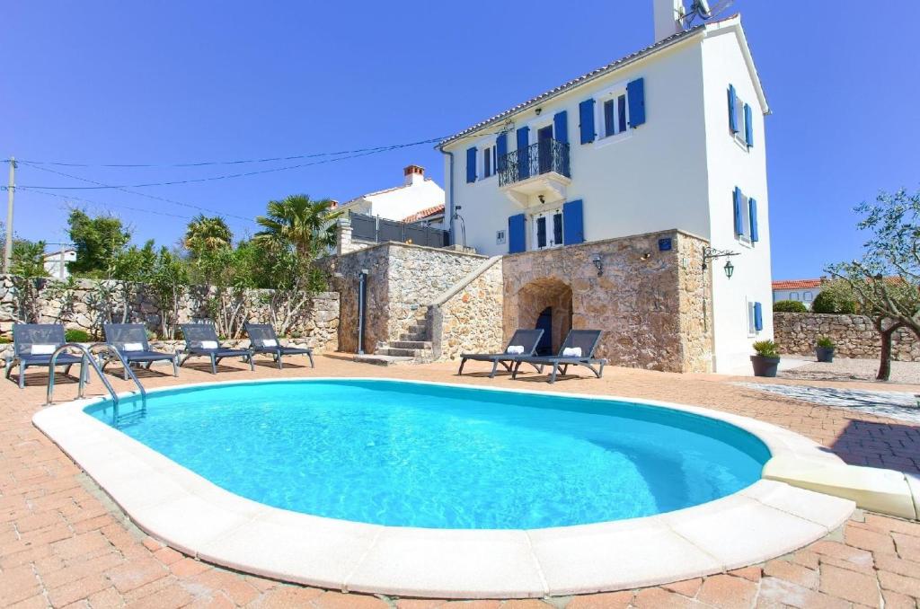 a swimming pool in front of a villa at Geschmackvoll eingerichtete Steinvilla mit Pool, großem Garten und besonderem Flair in Garica