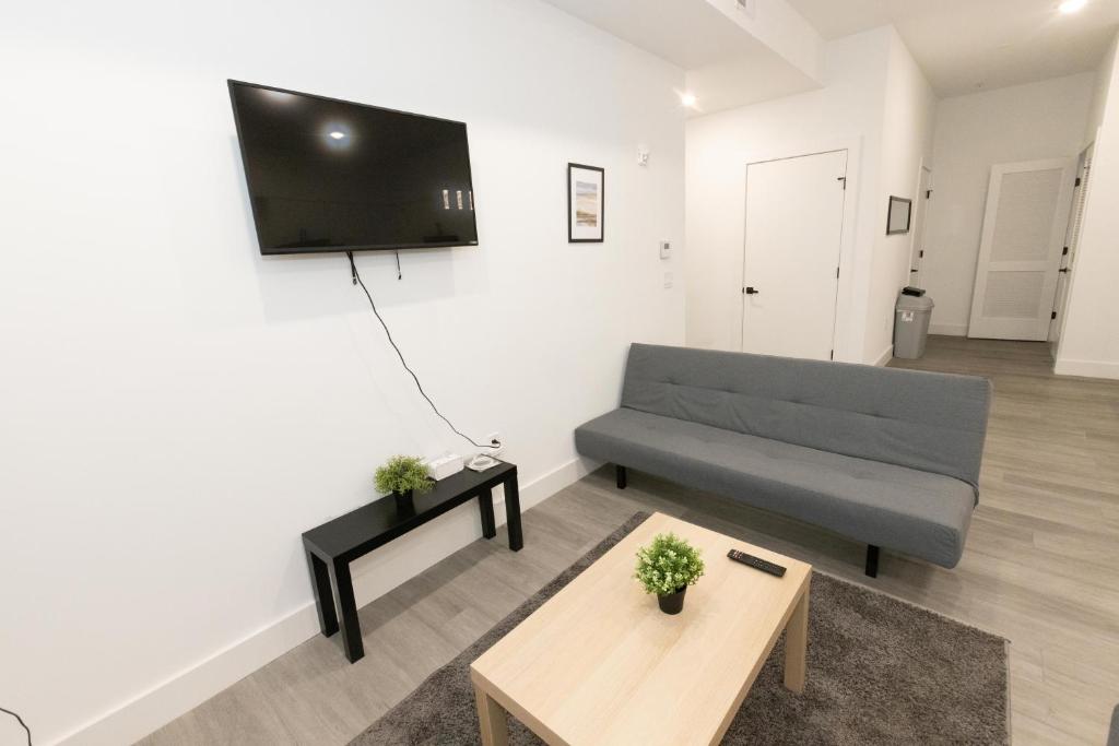 uma sala de estar com um sofá e uma televisão na parede em Chic 2-Bed Getaway Home-mins to NYC em Bayonne