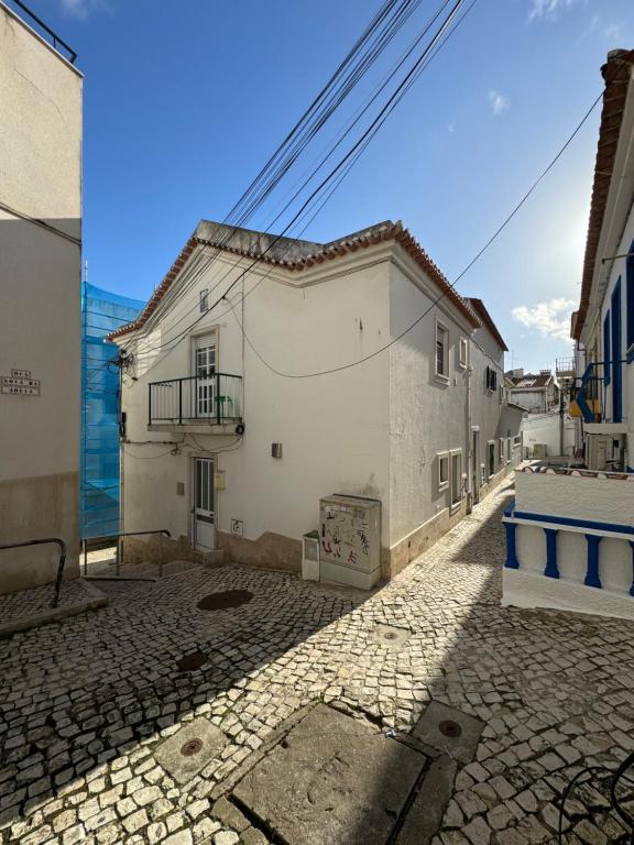 eine Straße mit zwei weißen Gebäuden und einem blauen Himmel in der Unterkunft Biá's House in Nazaré