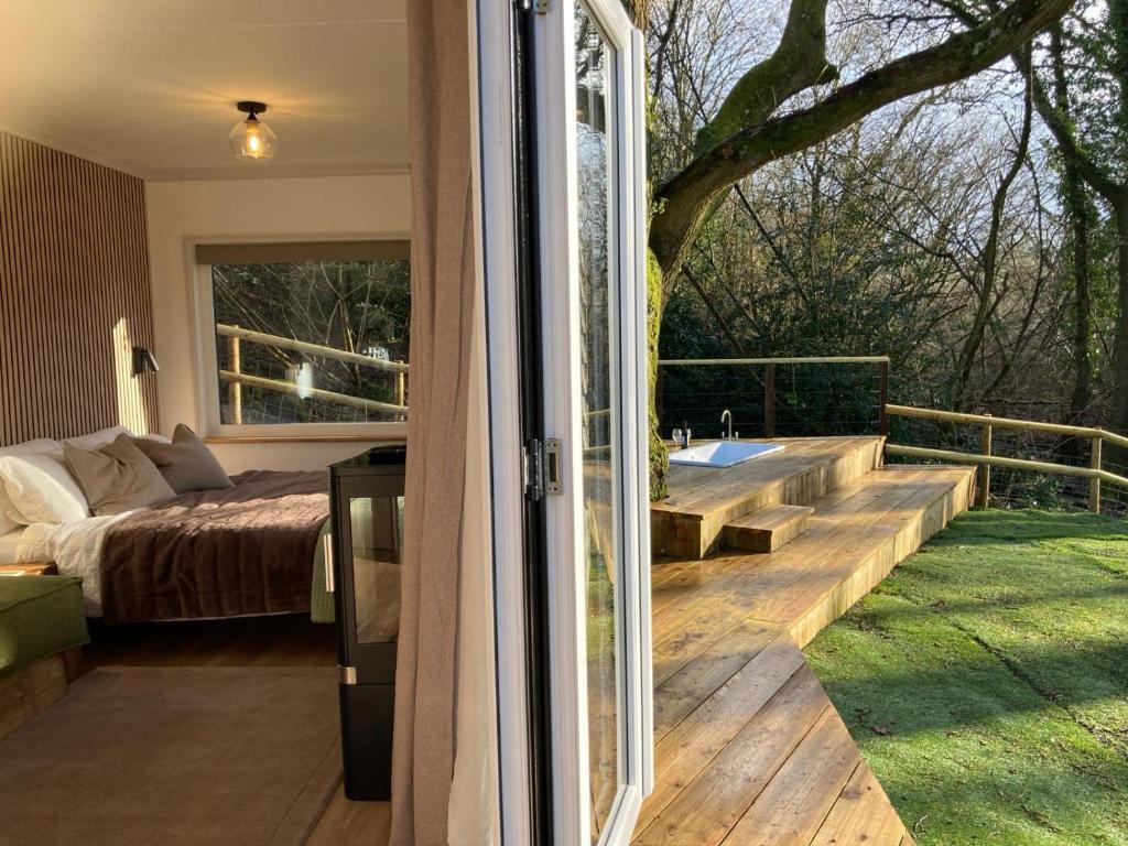 a room with a bed and a sliding glass door at The Cabin in the Woods in Romsey