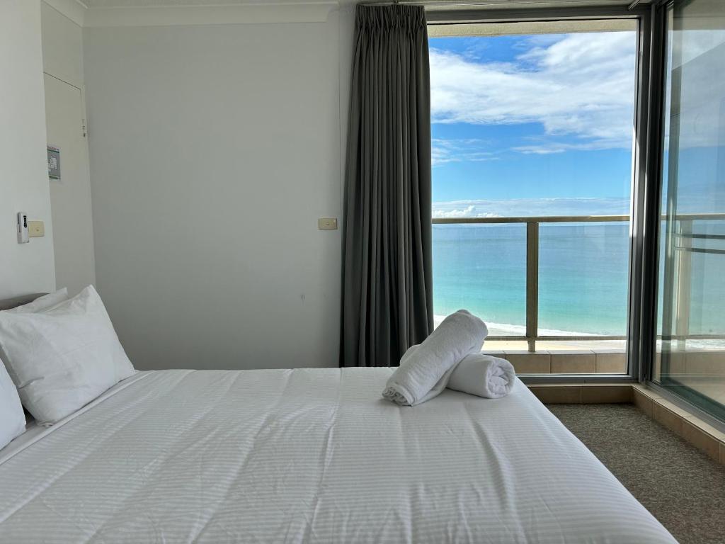 a bedroom with a bed with a view of the ocean at Ebbtide, Unit 37 in Forster