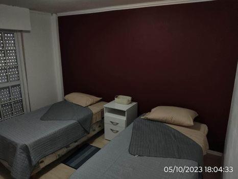 two beds in a small room with a window at Departamento “Edificio Manuelita” in Resistencia