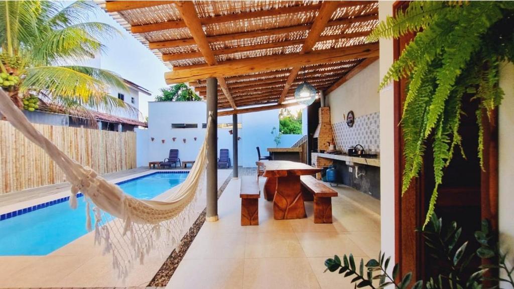 una hamaca en el lateral de una casa con piscina en Casa com 4 quartos, piscina e área gourmet, en Porto Seguro
